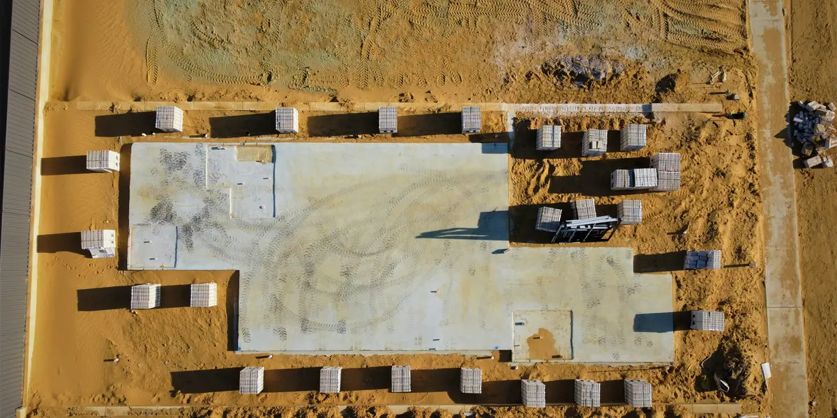 Builder using tape measure and stakes to square building footings with the 3-4-5 method